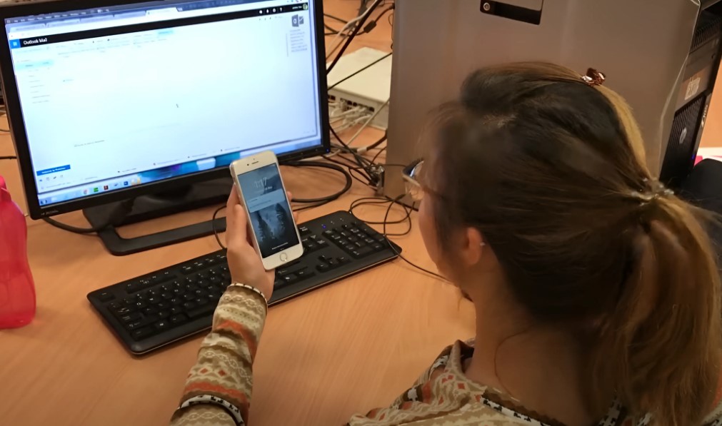 Girl working in office gets notification on the phone