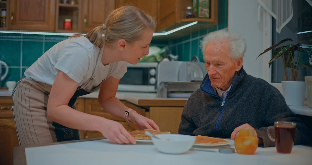 Serving food to an elderly man